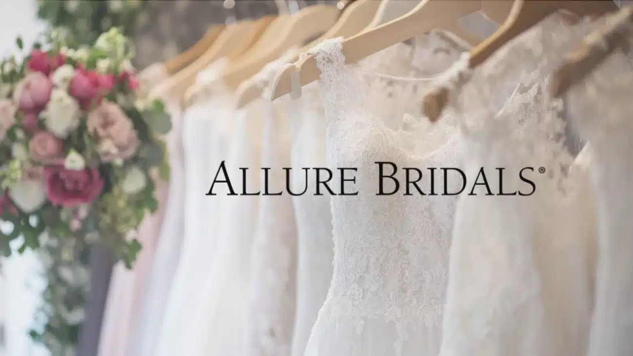 Allure Bridals logo over a rack of wedding dresses